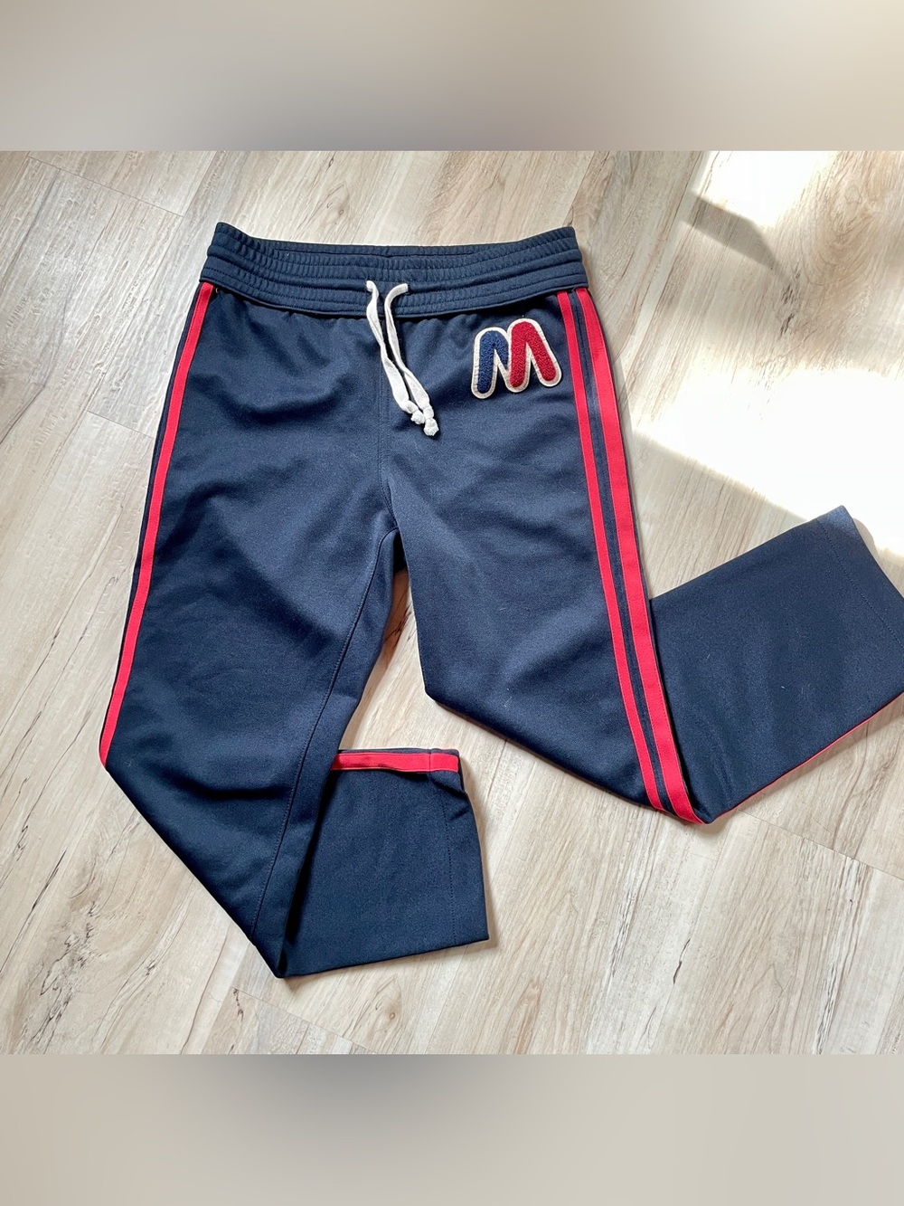 MOTHER Navy Track Pants with Red Side Stripes and 'M' Patch